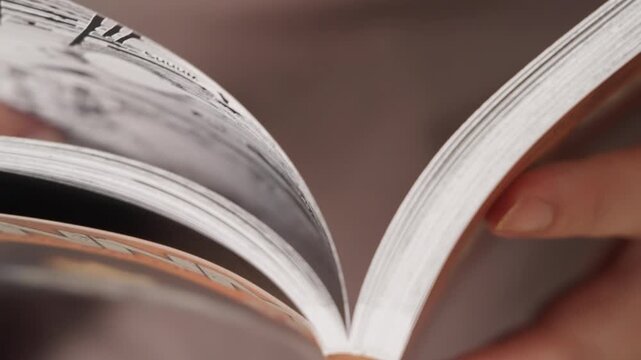 Person reading manga comic flipping through pages