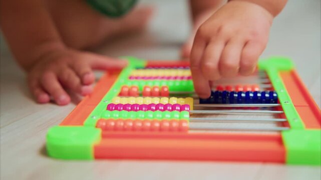Child's hands touch colorful beads. Fingers explore counting rods with curiosity. Bright frame draws attention to learning. Perfect for early education or playful math scenes