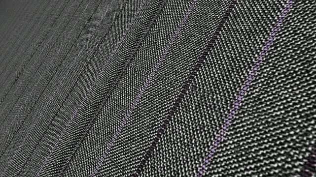 Premium Cinematic Movement Along Italian Charcoal Grey Herringbone Pinstripe Wool Fabric with Angled Camera View, Elegant Lighting and Detailed Weave