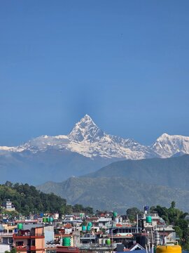 Mount Machhapuchhre (also known as the Fishtail mountain) towering behind the urban rooftops of Pokhara, Nepal.