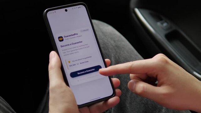 Borrower support goes digital as a user reviews a loan guarantee on a smartphone, highlighting co-signing, credit access, shared financial responsibility and lending risk.