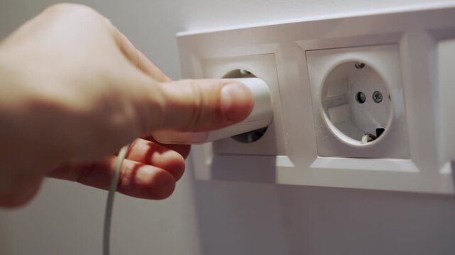 Close-up of a wall electrical outlet.
Plugging a charger into the outlet.