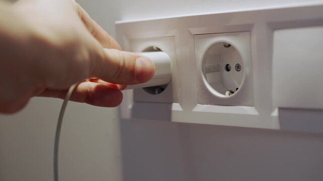 Close-up of a wall electrical outlet.
Plugging a charger into the outlet.