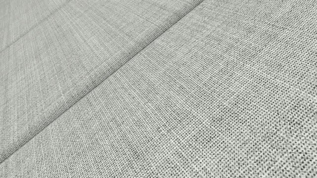 Refined Cinematic Movement Along Light Gray Fresco Wool Hopsack Fabric with Angled Camera View, Clear Lighting and Distinctive Open Weave Patterns