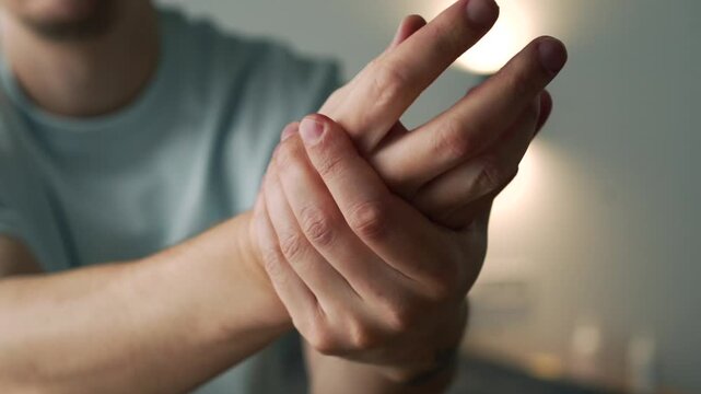 Young Man Rubbing Moisturizing Cream into His Hands to Prevent Dry Skin