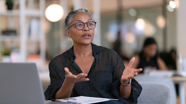 confident woman in white blouse speaking during a business meeting in a bright corporate conference room