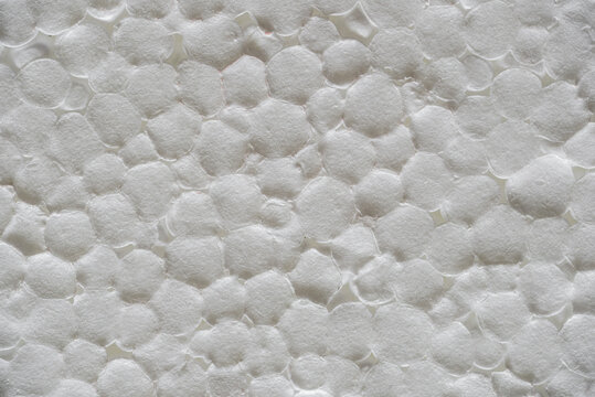 Macro closeup polystyrene foam surface revealing granular beads and irregular cells, soft shadows accentuate porous relief, subtle offwhite tonality, tactile industrial mood ideal