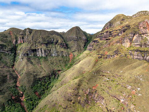 Aerial view of Codo de los Andes featuring rugged mountain slopes, rocky cliffs, and lush green vegetation under a cloudy sky, Samaipata, Santa Cruz Department, Bolivia.