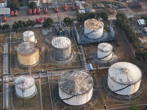 Aerial view of PT Pertamina Persero Terminal BBM Sanggaran with industrial fuel storage tanks, pipelines, and tanker trucks in Kecamatan Denpasar Selatan, Bali, Indonesia.