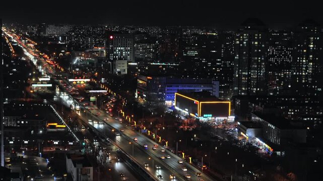 Night traffic on a main city road with commercial buildings in Beijing
