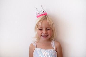  Little Blonde Girl Wearing Princess Crown and Dress on White Background © RealPeopleStudio