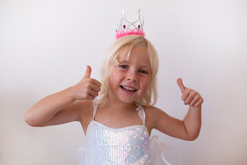 Happy Little Blonde Girl Wearing Princess Crown and Dress Showing Thumbs Up  © RealPeopleStudio