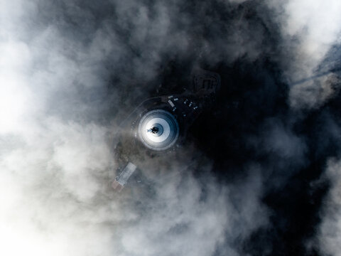 Aerial view of Jested Tower rising above a thick layer of clouds, with the surrounding mountain landscape partially visible in Liberec, Liberecky kraj, Czechia.