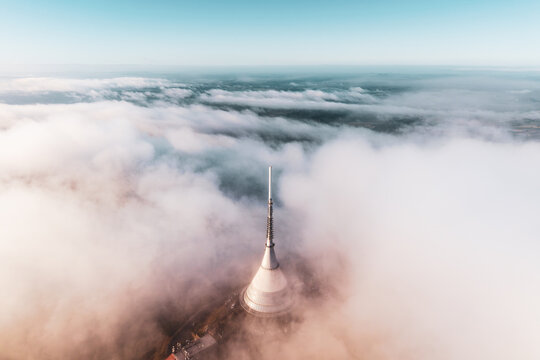 Aerial view of Jested Tower rising above a thick layer of clouds, with the peak visible in the soft light in Liberec, Liberecky kraj, Czechia.