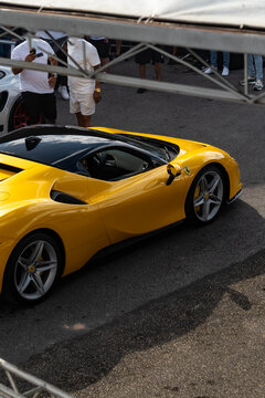 Yellow Ferrari F8 Tributo Supercar High Angle Side Profile Parked At Outdoor Event On Asphalt Ground
