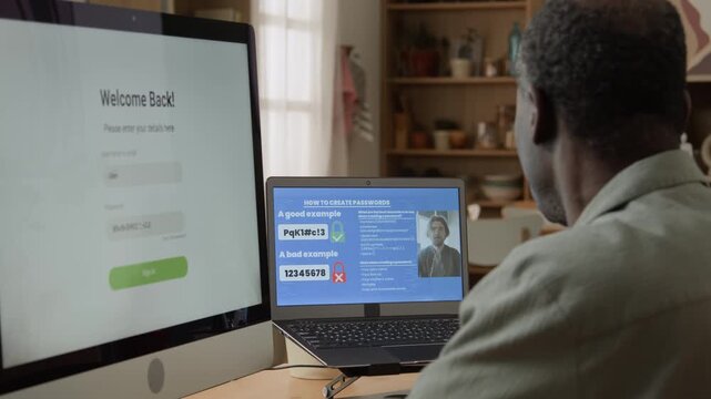 Senior African American man watching password security tutorial on laptop screen at desk. Clip suitable for cyber safety awareness programs, IT training modules, and digital education videos