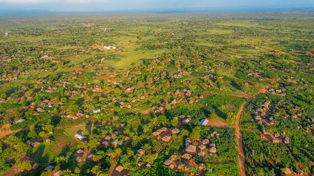Aerial view of the rural landscape of Yumbe, featuring scattered traditional huts, small agricultural plots, and dirt roads amidst lush green vegetation in Yumbe, Northern Region, Uganda.