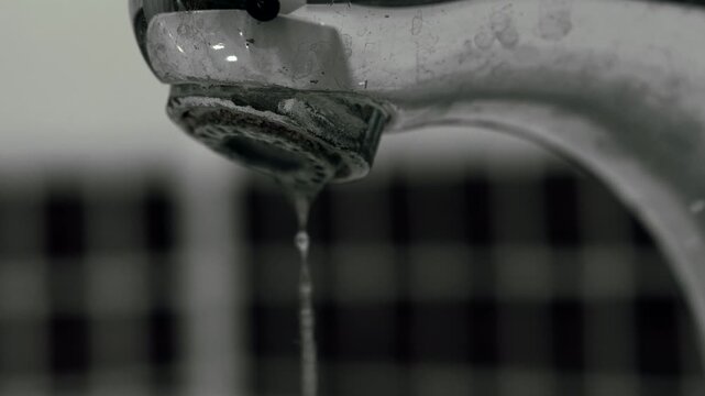 A dirty hotel tap dripping water