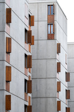Modern apartment buildings with plain concrete walls and irregular brown window shutters create a quiet geometric study of residential architecture and urban housing