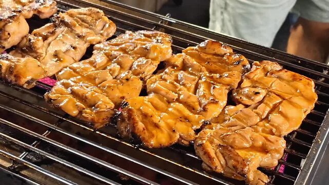 delicious glazed grilled chicken thigh meat steaks cooking on hot charcoal barbecue metal wire grill grate