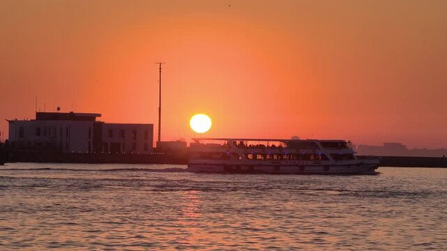 Sunset view over water with a boat moving in the foreground
