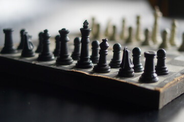 A chessboard against a black background. a game that relies on strategy and intellect. © Randa