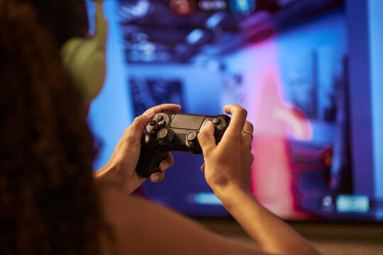 Close up of multi-ethnic young adult woman hands holding gamepad controller playing online video game. Visual concept for gaming industry, esports and digital entertainment marketing