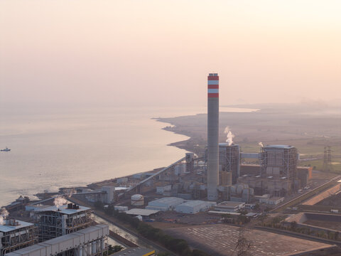 Aerial view of PLTU Tanjung Jati power plant with its tall chimney and industrial structures situated along the coastline, Kecamatan Kembang, Jawa Tengah, Indonesia.