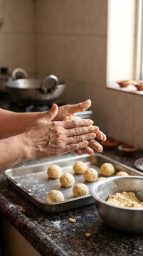 Hands shaping imperfect homemade gulab jamun during an authentic Diwali preparation.