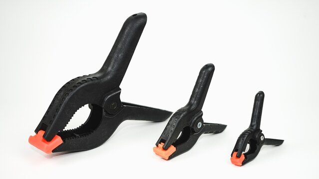 Set of three black plastic spring clamps isolated on white background