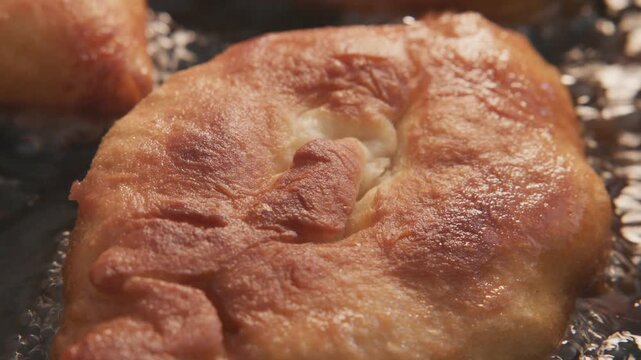 Golden, fluffy pastry sizzles in hot oil. Bubbling, crispy edges glisten with heat. Texture promises warmth and comfort. Perfect for food blogs or cooking shows. No people, no animals