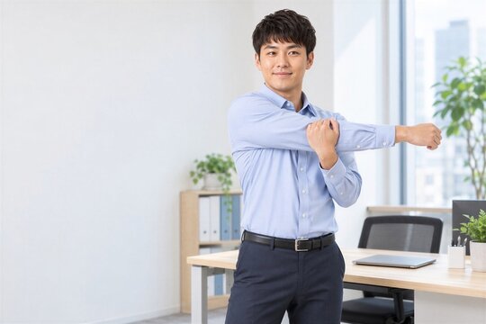 仕事の合間に肩をストレッチする日本人男性会社員