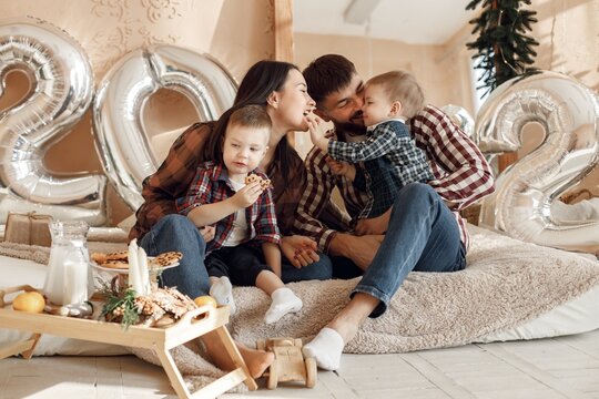 Young family in plaid shirts sitting on a floor near mirror