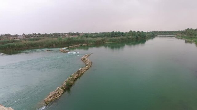 Aerial view of a stone weir crossing the calm Euphrates River near Hit, Anbar, Iraq