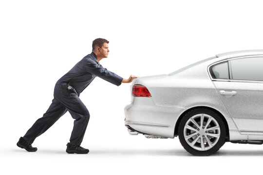 Profile shot of a mechanic pushing a car