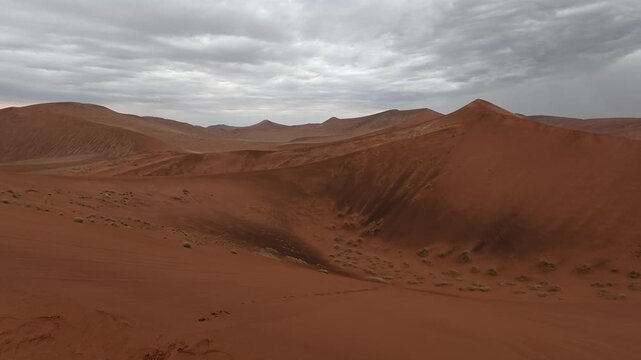 A panorama of sand dunes at sunset. Desert landscape, cloud shadows on the dunes