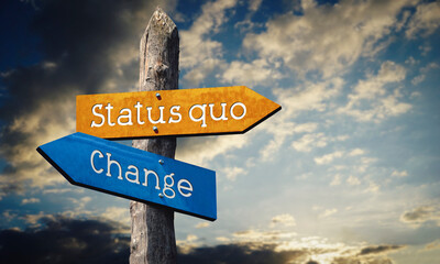 Status quo or change - wooden signpost with two arrows, sunset sky in background © PX Media
