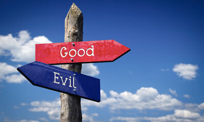 Good or evil - wooden signpost with two arrows, sky with clouds © PX Media