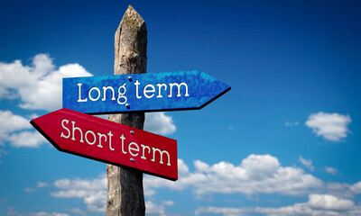 Long or short term - wooden signpost with two arrows, sky with clouds © PX Media