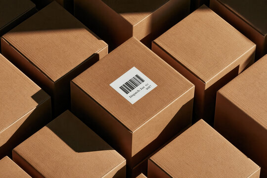 Cardboard boxes with barcodes stacked closely together in a warehouse setting
