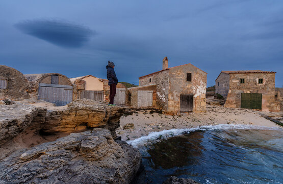 hiker observing  Old fishermen's huts Ses Roquetes, Col&ograve;nia de Sant Jordi, Mallorca, Balearic Islands, Spain