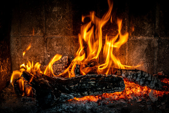 Burning wooden logs and glowing embers inside a fireplace, Mallorca, Balearic Islands, Spain