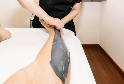 Esthetician waxing a man's leg