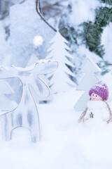 Close up of Christmas wooden reindeer and doll in snow, winter holiday background and vertical card design © Jurga Jot