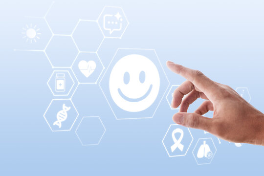 Hand touching digital smiley icon with health and wellness symbols