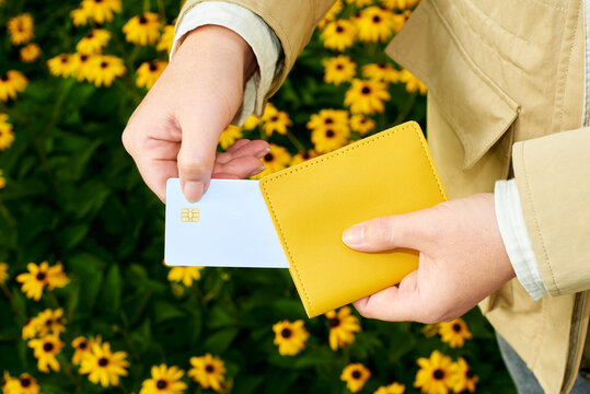 Person takes card from yellow wallet