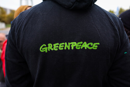 Details with the Greenpeace logo on the clothes of a person during a protest.