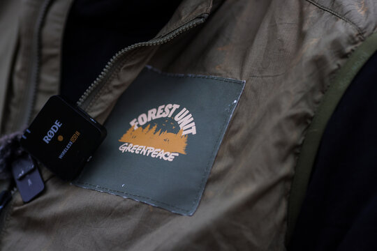 Details with the Greenpeace (Forest Unit) logo on the clothes of a person during a protest.