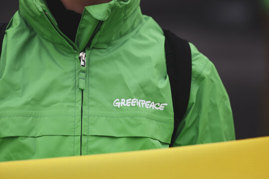 Details with the Greenpeace logo on the clothes of a person during a protest.