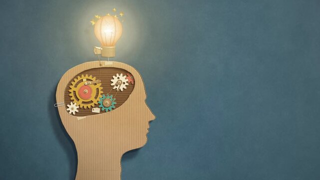 Cardboard head with turning paper gears switches on a glowing paper light bulb, creative idea and innovation concept, seamless loop with copy space